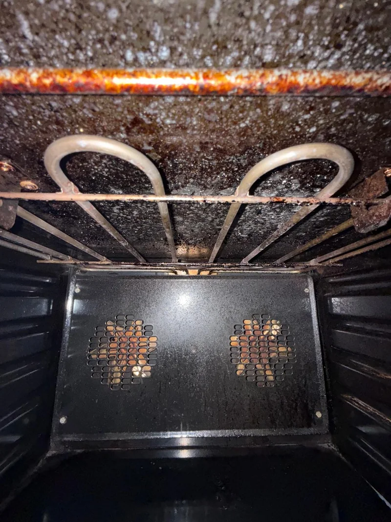 Accumulated grease inside an oven and on its heating elements