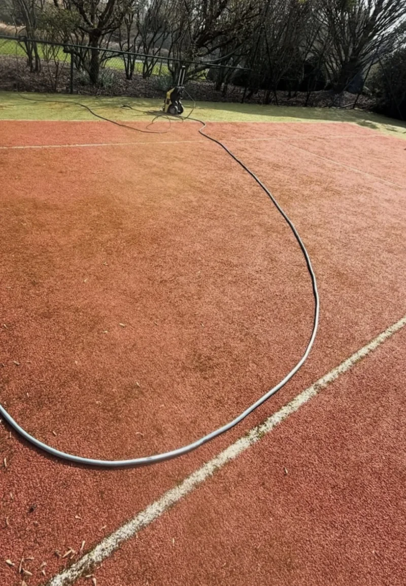 Equipment and hose during deep cleaning of the tennis court